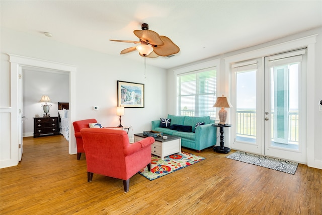 living room with wood-type flooring, french doors, and ceiling fan