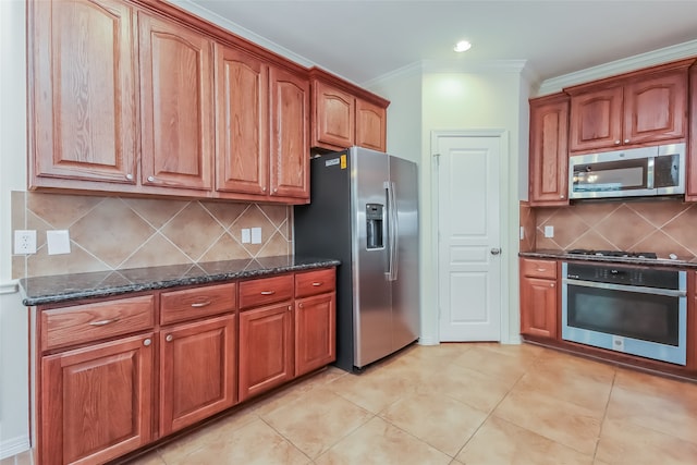 kitchen with backsplash, appliances with stainless steel finishes, dark stone counters, and light tile patterned floors