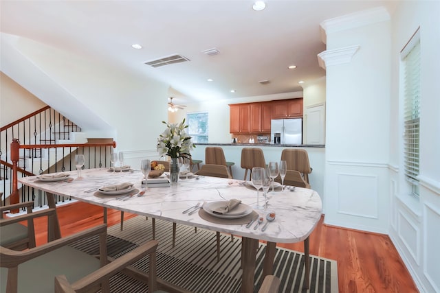 dining space with crown molding, light wood-type flooring, and ceiling fan