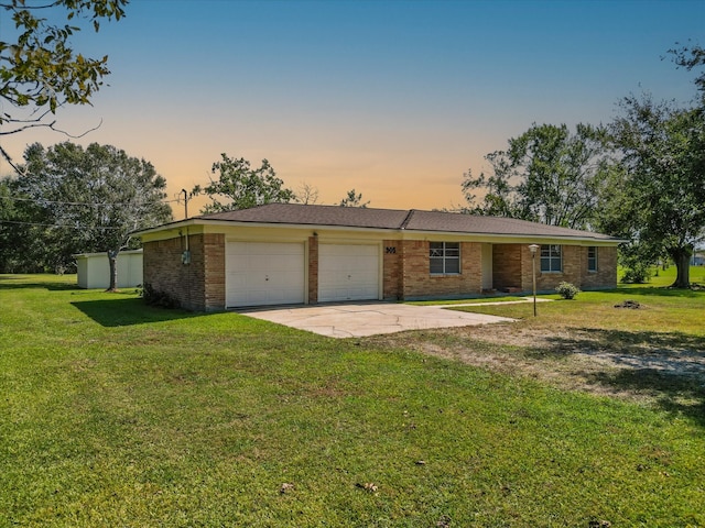 ranch-style home with a yard and a garage