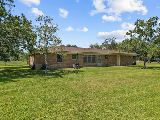 rear view of house featuring a yard and cooling unit