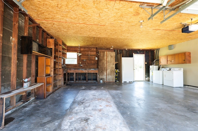 garage featuring a garage door opener, electric water heater, washer and clothes dryer, and white refrigerator