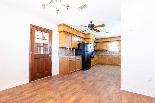 kitchen with decorative backsplash, wood-type flooring, sink, and black fridge