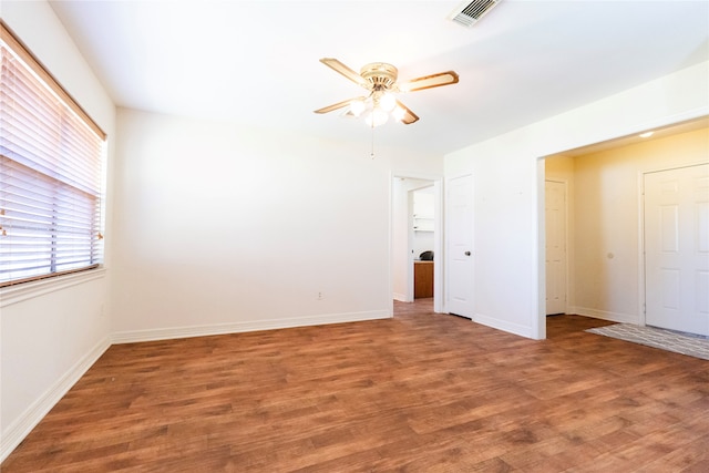 unfurnished room featuring dark wood-type flooring and ceiling fan