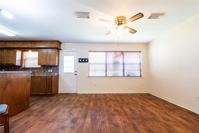 kitchen with dark wood-type flooring, ceiling fan, and decorative backsplash