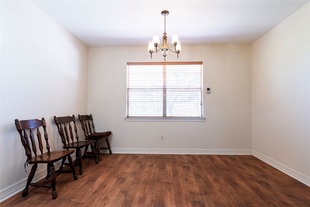 living area featuring dark wood-type flooring and an inviting chandelier