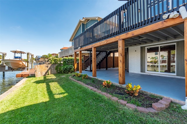 view of yard with a boat dock, a patio area, and a deck with water view