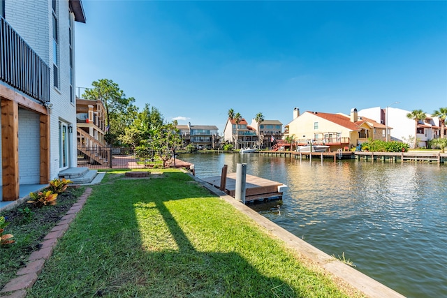 view of dock with a water view and a yard