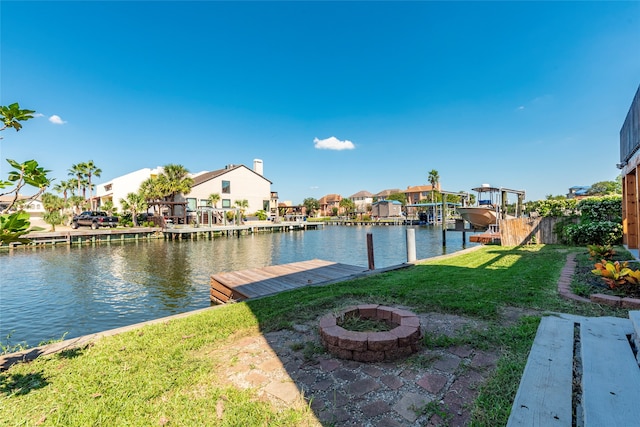 dock area featuring a fire pit, a yard, and a water view