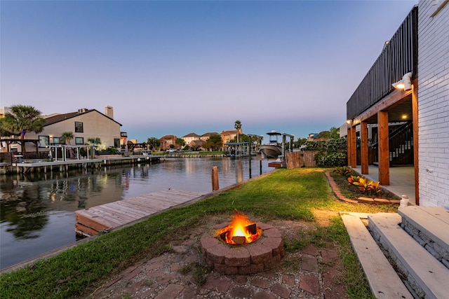 dock area featuring a water view, a fire pit, and a patio area