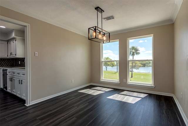 unfurnished dining area featuring a water view, dark hardwood / wood-style floors, a chandelier, ornamental molding, and a textured ceiling