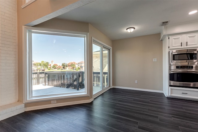 kitchen with stainless steel appliances, plenty of natural light, dark hardwood / wood-style floors, and white cabinetry