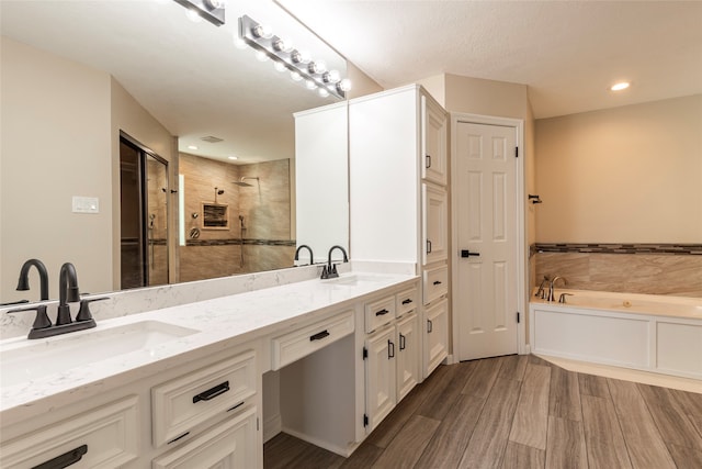 bathroom featuring a textured ceiling, hardwood / wood-style floors, vanity, and independent shower and bath