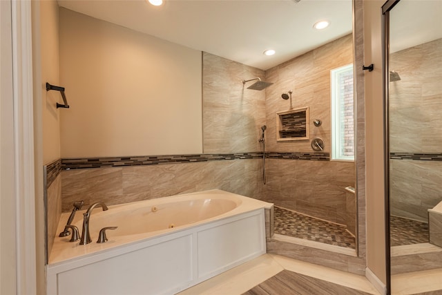 bathroom with separate shower and tub and tile walls