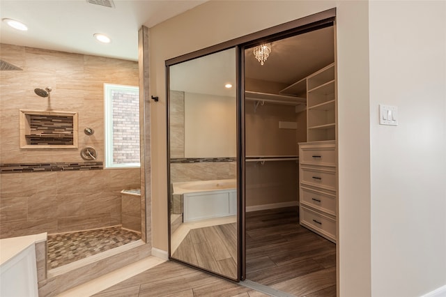 bathroom with independent shower and bath, vanity, and tile walls