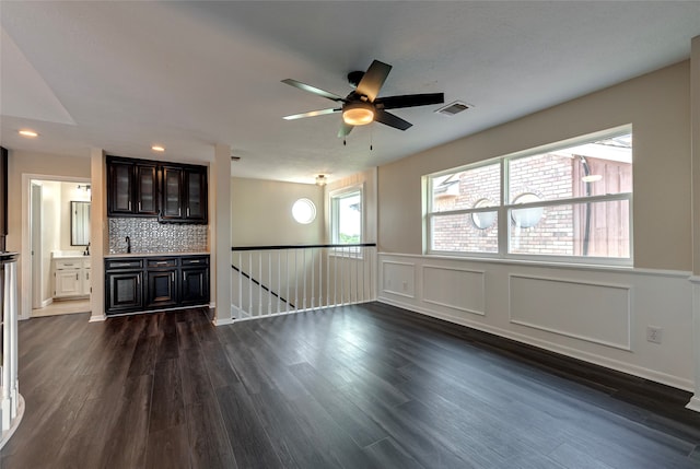 unfurnished living room with dark wood-type flooring and ceiling fan