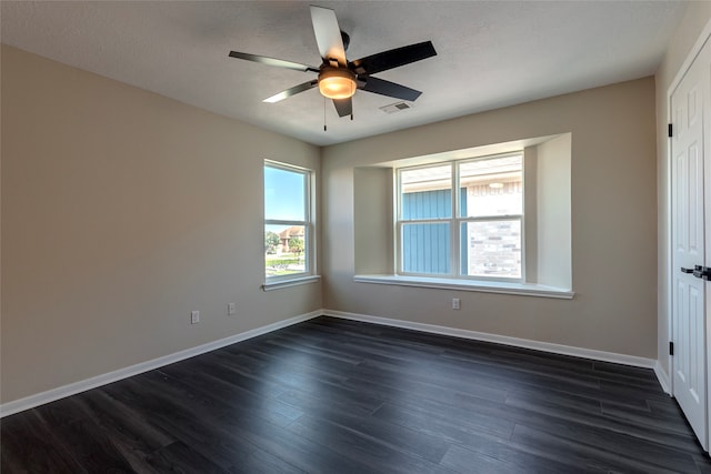 empty room featuring ceiling fan, a textured ceiling, and dark hardwood / wood-style floors