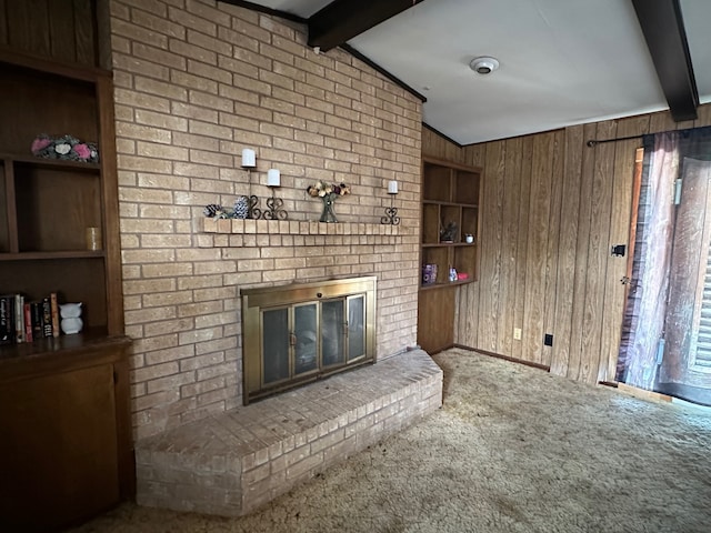 unfurnished living room featuring carpet floors, vaulted ceiling with beams, wooden walls, and a fireplace