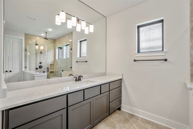 bathroom featuring vanity, a shower with shower door, and a wealth of natural light