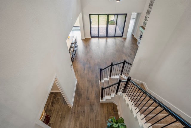 stairs featuring hardwood / wood-style flooring and a towering ceiling