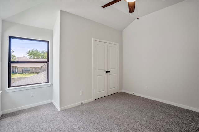 unfurnished bedroom featuring ceiling fan, lofted ceiling, a closet, and carpet