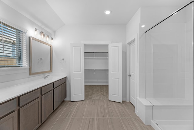 bathroom featuring tile patterned flooring, vanity, and a shower