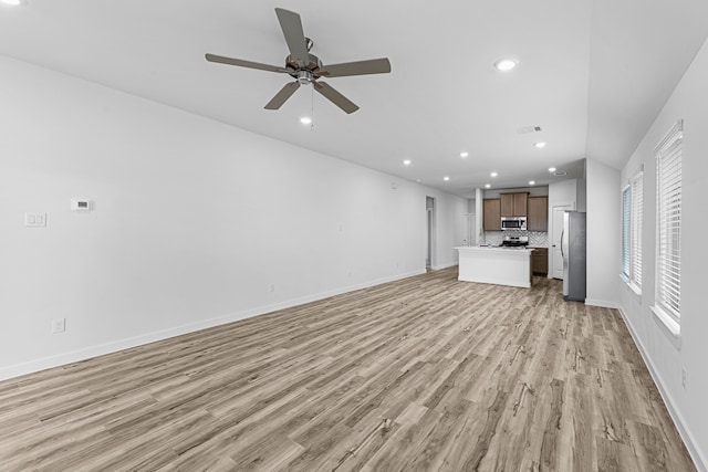 unfurnished living room featuring ceiling fan and light hardwood / wood-style flooring