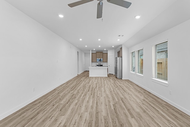 unfurnished living room featuring light wood-type flooring and ceiling fan