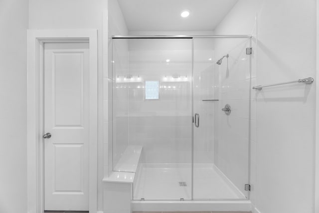 bathroom with a shower with door