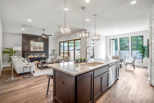 kitchen featuring a center island with sink, a large fireplace, a healthy amount of sunlight, and sink