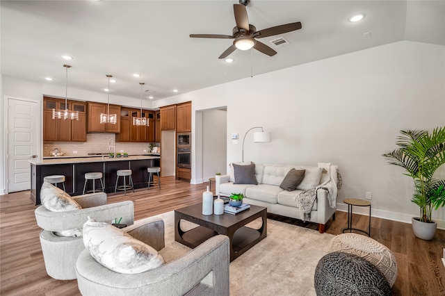 living room featuring light wood-type flooring, ceiling fan, and lofted ceiling