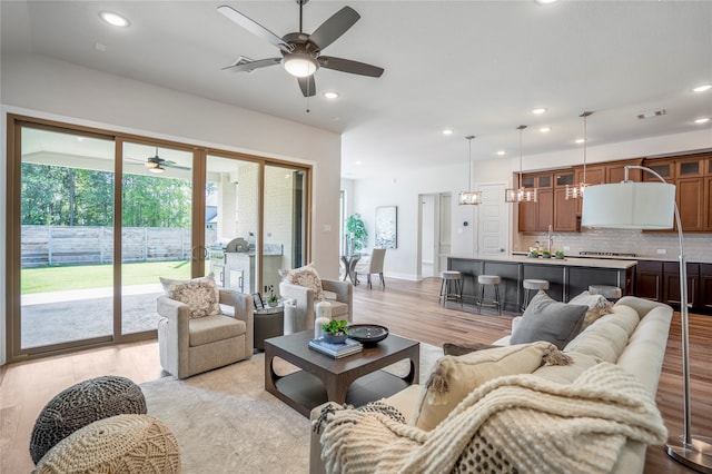 living room with ceiling fan and light hardwood / wood-style floors