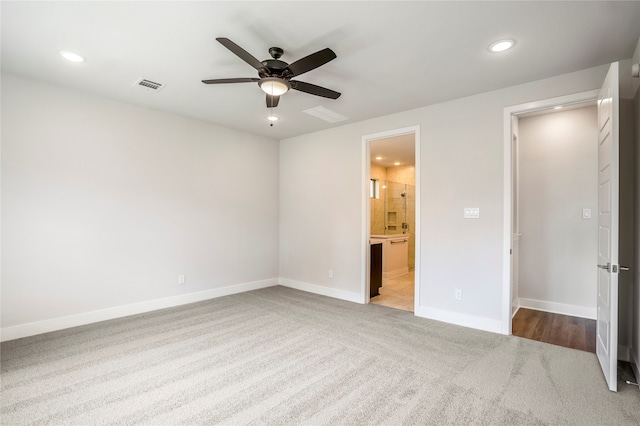 unfurnished bedroom with ceiling fan, connected bathroom, and carpet