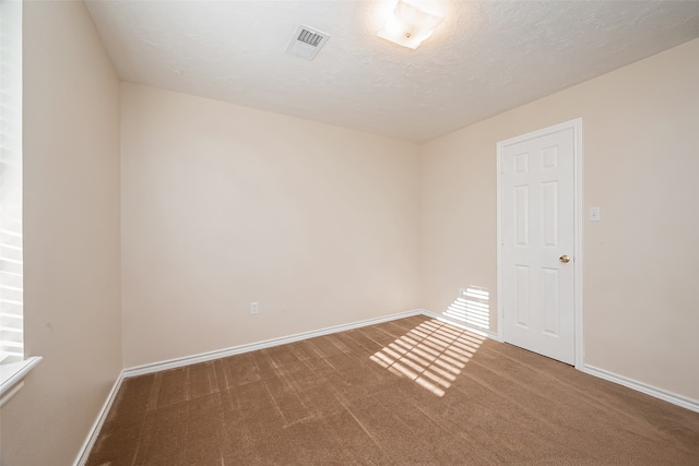 empty room featuring carpet flooring and a textured ceiling