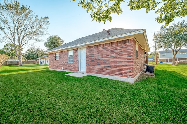 rear view of property with a lawn and central AC