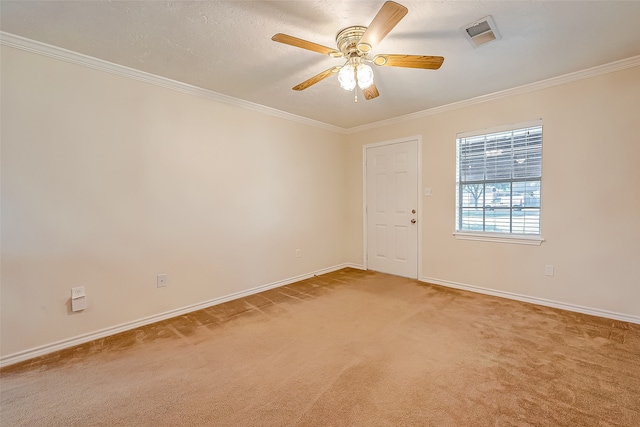 empty room with crown molding, ceiling fan, and carpet