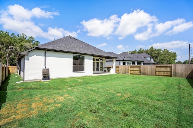 back of property with a yard and a patio area