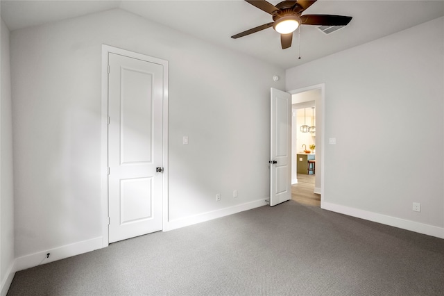 unfurnished bedroom featuring ceiling fan, vaulted ceiling, and carpet flooring