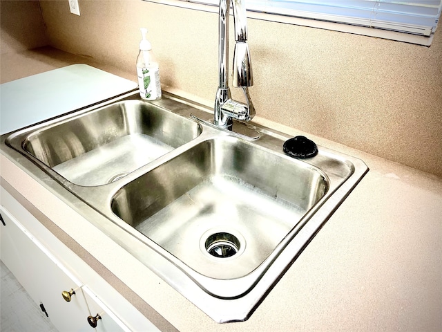 room details featuring sink and white cabinets