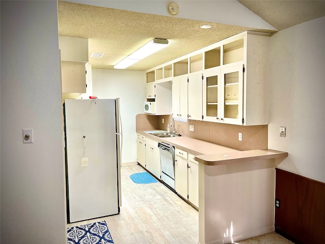 kitchen featuring white cabinets, white appliances, sink, light hardwood / wood-style flooring, and a textured ceiling