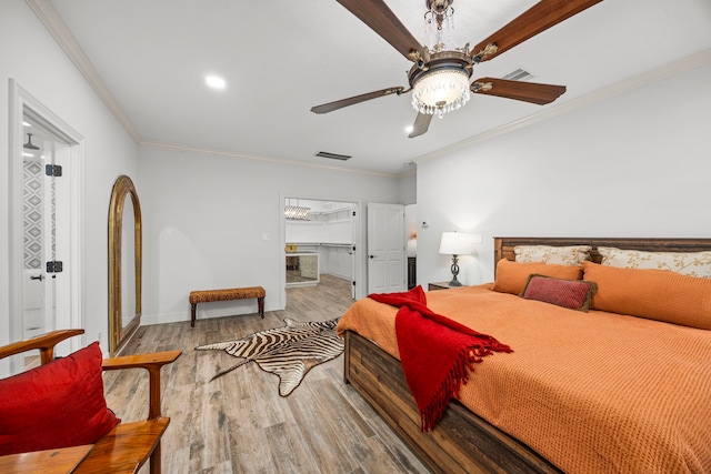 bedroom featuring ornamental molding, hardwood / wood-style floors, connected bathroom, and ceiling fan