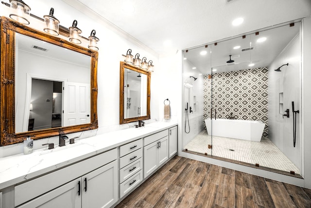 bathroom featuring ornamental molding, vanity, wood-type flooring, and shower with separate bathtub