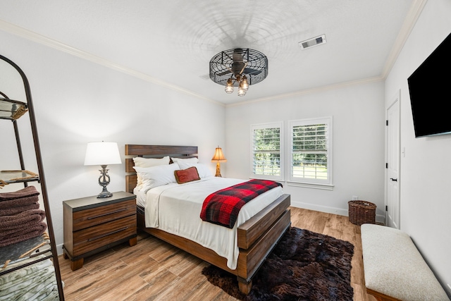 bedroom with light hardwood / wood-style floors and ornamental molding