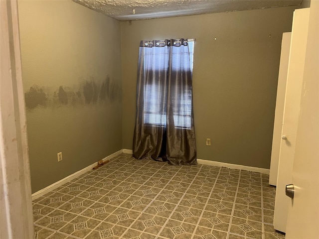 unfurnished room featuring a textured ceiling