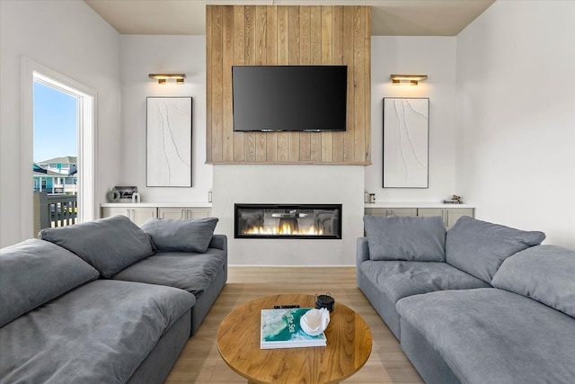 living room with light wood-type flooring and a large fireplace