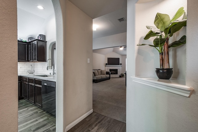 hall featuring lofted ceiling, light hardwood / wood-style floors, and sink