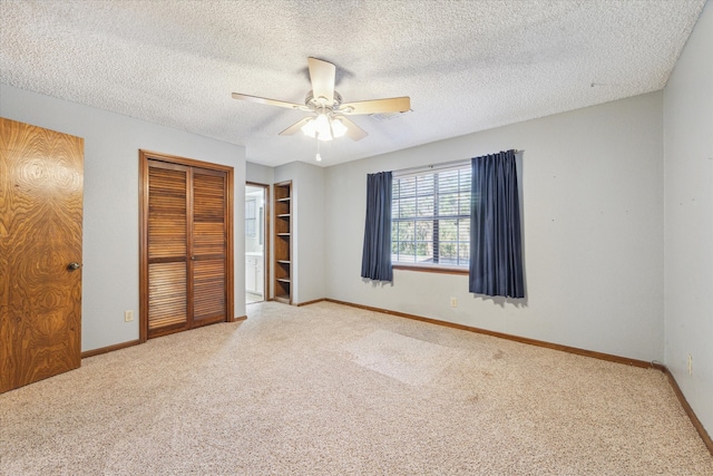 unfurnished bedroom with carpet floors, a textured ceiling, and ceiling fan