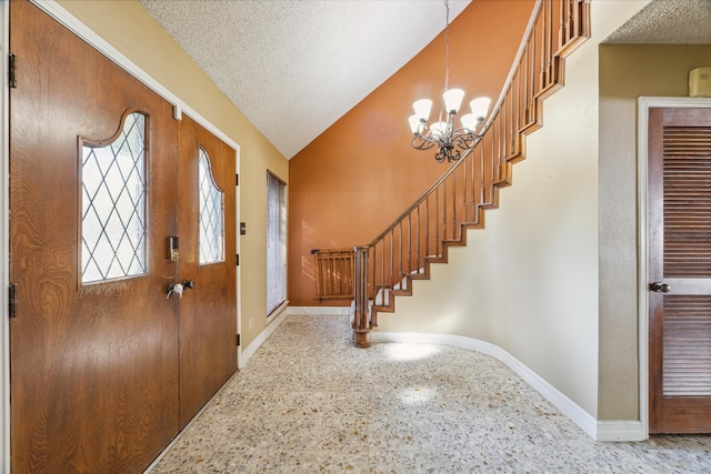 foyer featuring vaulted ceiling, a chandelier, and a textured ceiling