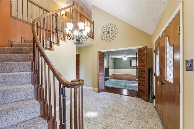 entrance foyer featuring vaulted ceiling, a chandelier, and a textured ceiling