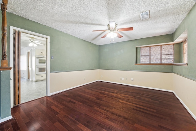 spare room featuring ceiling fan, wood-type flooring, and a textured ceiling